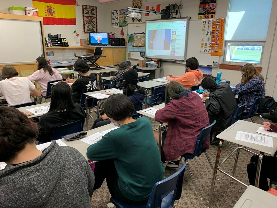 high school students writing a test in a classroom